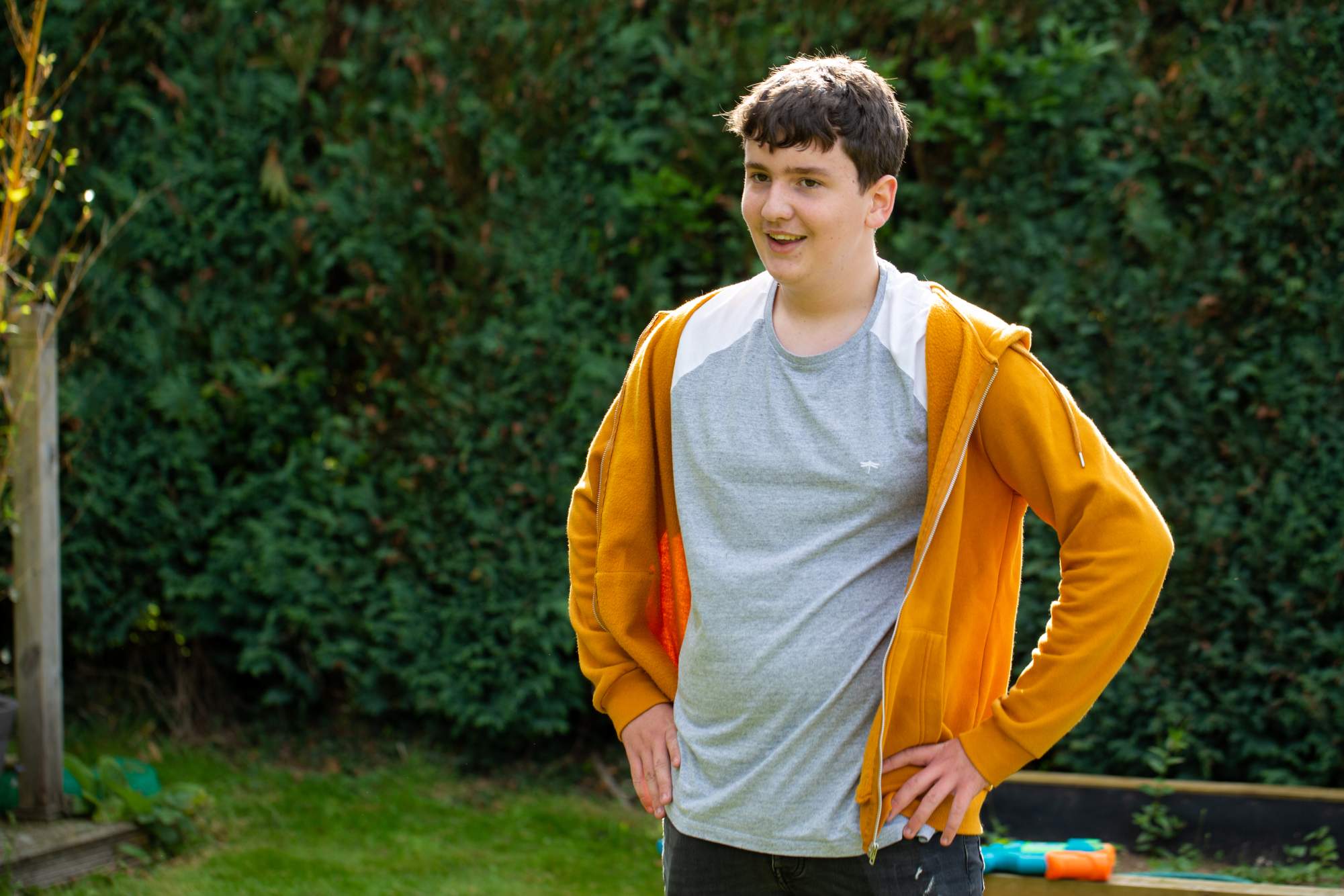 A teenage boy with his hands on his hips