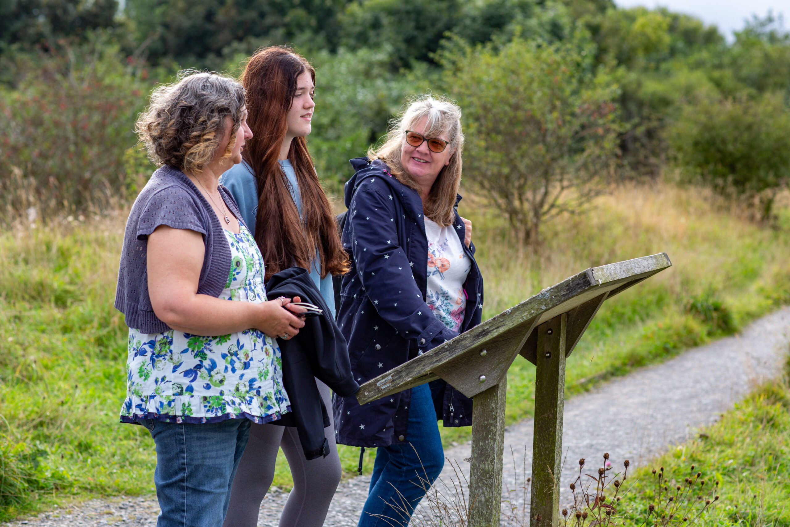Teenage girl with two ladies at country park